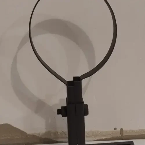 Een mat zwarte muurbeugel op een wit bureau voor een beige muur