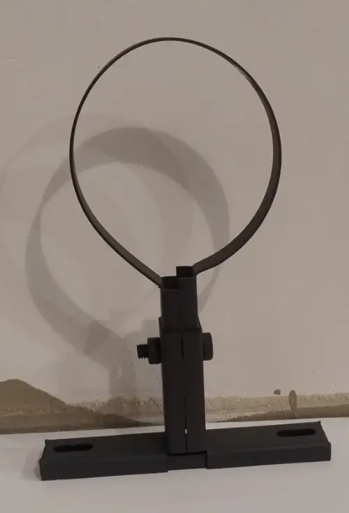 Een mat zwarte muurbeugel op een wit bureau voor een beige muur